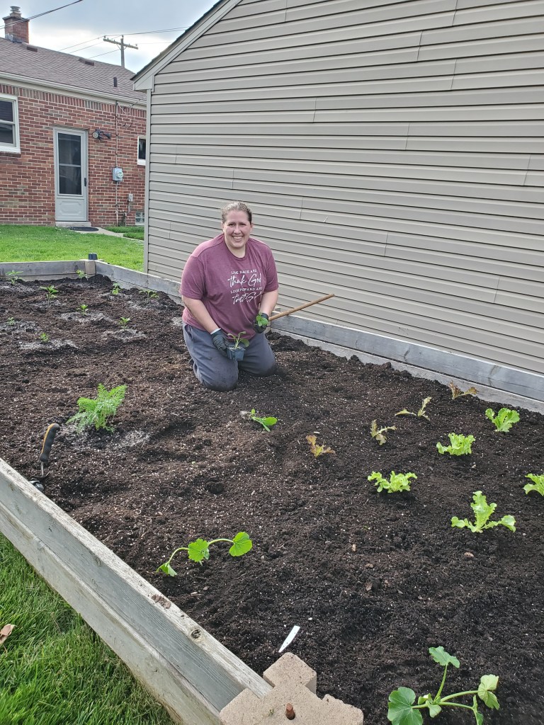 Becky planting some veggies in the garden.